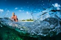 Happy surfer rides the clear ocean wave