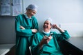 Happy surgeons interacting while using mobile phone Royalty Free Stock Photo