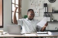 Happy surprised African American businessman reading good news in letter, celebrating success, excited young man holding Royalty Free Stock Photo