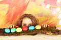 Happy surprised easter girl with colorful eggs and tulip flowers