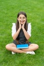 Happy surprised teen school girl sitting on grass. School and education. Back to school. Royalty Free Stock Photo