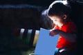 Happy surprised three years old boy reading book magic fairytale on dark background, light comes from book, isolated book