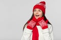 Happy surprised woman looking sideways in excitement. Excited christmas girl wearing knitted warm hat and scarf, isolated on gray Royalty Free Stock Photo