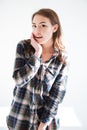 Happy surprised young woman in plaid shirt