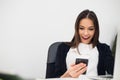 Happy surprising woman looking in mobile phone and reading message with open mouth