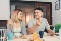 Happy sweet Asian couple having breakfast, cereal in milk, bread and drinking orange juice after wake up in the morning. Husband Royalty Free Stock Photo