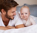 Happy, sweet and baby with father on bed relaxing, playing and bonding together at home. Smile, love and young dad Royalty Free Stock Photo
