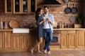 Happy sweet barefooted young couple drinking coffee in kitchen together