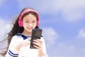 Happy syudent girl  listening music in headphones, holding mobile phone Royalty Free Stock Photo