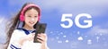 Happy syudent girl  listening music in headphones and holding mobile phone with 5G network concepts Royalty Free Stock Photo