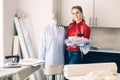 Happy tailor woman with a new clothes and tailor tools in her design studio atelier. Royalty Free Stock Photo