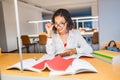 Happy teacher with glasses in library checking homework of her students Royalty Free Stock Photo