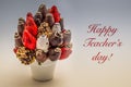 Happy Teacher`s greeting card with red lettering; A bundle of edible flowers, arrangement of strawberries covered with chocolate