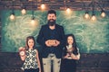 Happy teacher and schoolgirls at chalkboard. Bearded man and small girls smile at green board. Tutor and pupils with Royalty Free Stock Photo