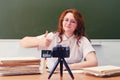 Happy teacher shows a gesture of success - thumbs up during an online lesson at school