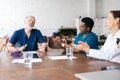 Happy team of dedicated multi-ethnic of professional doctors applauding their chief physician. Royalty Free Stock Photo