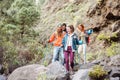 Happy team friends doing trekking excursion on mountains - Group young tourists hiking and exploring the wild nature