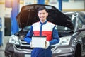 Happy technician or auto mechanic Reassuring the car battery in auto repair car service center