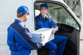 Happy Technician Giving Toolbox To Colleague