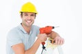 Happy technician holding drill machine while leaning on ladder Royalty Free Stock Photo