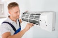 Happy Technician Repairing Air Conditioner Royalty Free Stock Photo