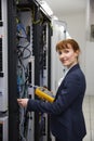 Happy technician using digital cable analyzer on server Royalty Free Stock Photo