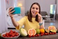 Happy teen blogger eating carrot