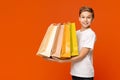 Happy teen boy holding lots of colorful paper shopping bags Royalty Free Stock Photo