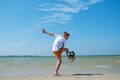 Happy teen boy playing with ball on beach at summer sunny day with blue sky Royalty Free Stock Photo