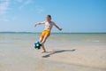 Happy teen boy playing with ball on beach at summer sunny day with blue sky Royalty Free Stock Photo