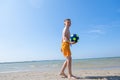 Happy teen boy playing with ball on beach at summer sunny day with blue sky Royalty Free Stock Photo