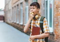 Happy teen boy portrait on the way to school, he is eating an apple, education and back to school concept Royalty Free Stock Photo