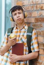 Happy teen boy portrait on the way to school, he is eating an apple, education and back to school concept Royalty Free Stock Photo