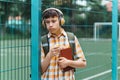 Happy teen boy portrait on the way to school, he is eating an apple, education and back to school concept Royalty Free Stock Photo