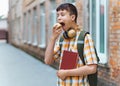 Happy teen boy portrait on the way to school, he is eating an apple, education and back to school concept Royalty Free Stock Photo