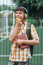 Happy teen boy portrait on the way to school, he is eating an apple, education and back to school concept Royalty Free Stock Photo