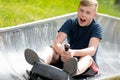 Happy teen boy riding at bobsled roller coaster rail track