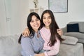 Happy teen child daughter hugging young indian mother at home, portrait. Royalty Free Stock Photo