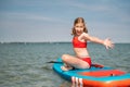 Happy teen child girl having fun on sup board in sea at summer holidays Royalty Free Stock Photo