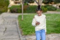 Happy teen child works in the phone, looking into it,pay goods.Teen girl young blogger reading good news on mobile phone Royalty Free Stock Photo