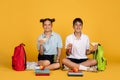 Happy teen european boy and girl with backpacks eating apple and sandwich, drink juice bottle Royalty Free Stock Photo