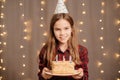 Happy teen girl with birthday cake. tradition to make wish and blow out fire Royalty Free Stock Photo