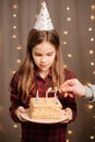 Happy teen girl with birthday cake. tradition to make wish and blow out fire Royalty Free Stock Photo