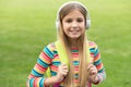 Happy teen girl carrying school bag listening to music in headphones outdoors Royalty Free Stock Photo