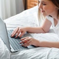 Happy teen girl communicates online working remote, studying or planning her day use computer laptop in bedroom. Young Royalty Free Stock Photo