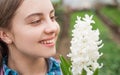 happy teen girl florist care pot plants in greenhouse, flower