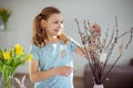 Happy teen girl hanging Easter eggs on a spring branch Royalty Free Stock Photo