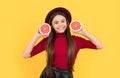 happy teen girl in hat with grapefruit. vitamin and dieting. child eating healthy food.