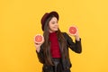 happy teen girl in hat and leather jacket hold cut grapefruit, vitamin