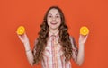 happy teen girl hold citric fruit on orange background
